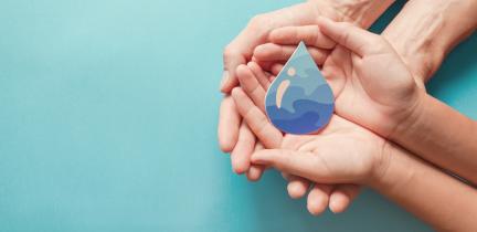 Photo: Two pairs of hands holding a cutout of a water drop