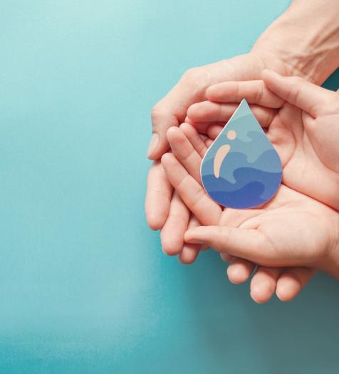 Photo: Two pairs of hands holding a cutout of a water drop